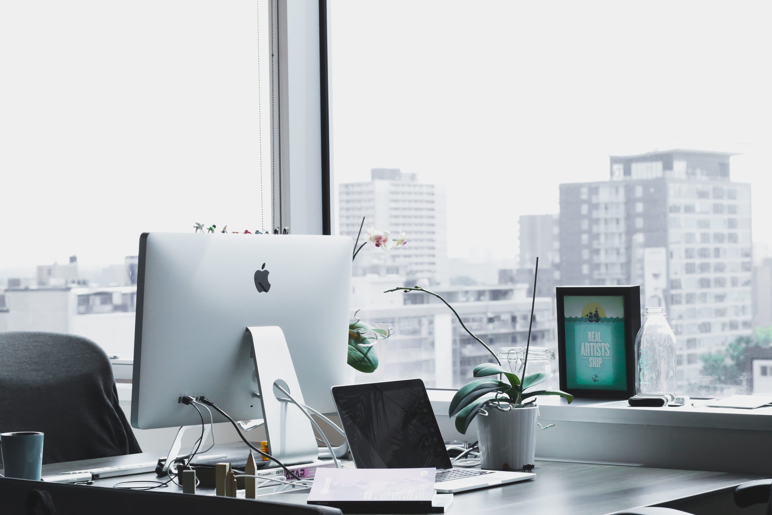 Office scene with desk and computer with a clean window backdrop with solar window film