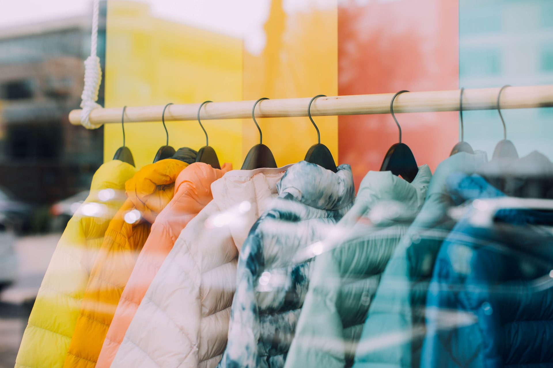 Coats hanging in a glass retail storefront with loss prevention