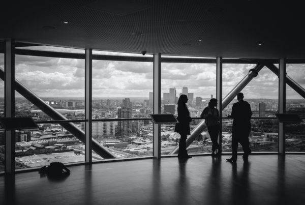 People standing by a window discussing how to select a 3M Window Film Dealer