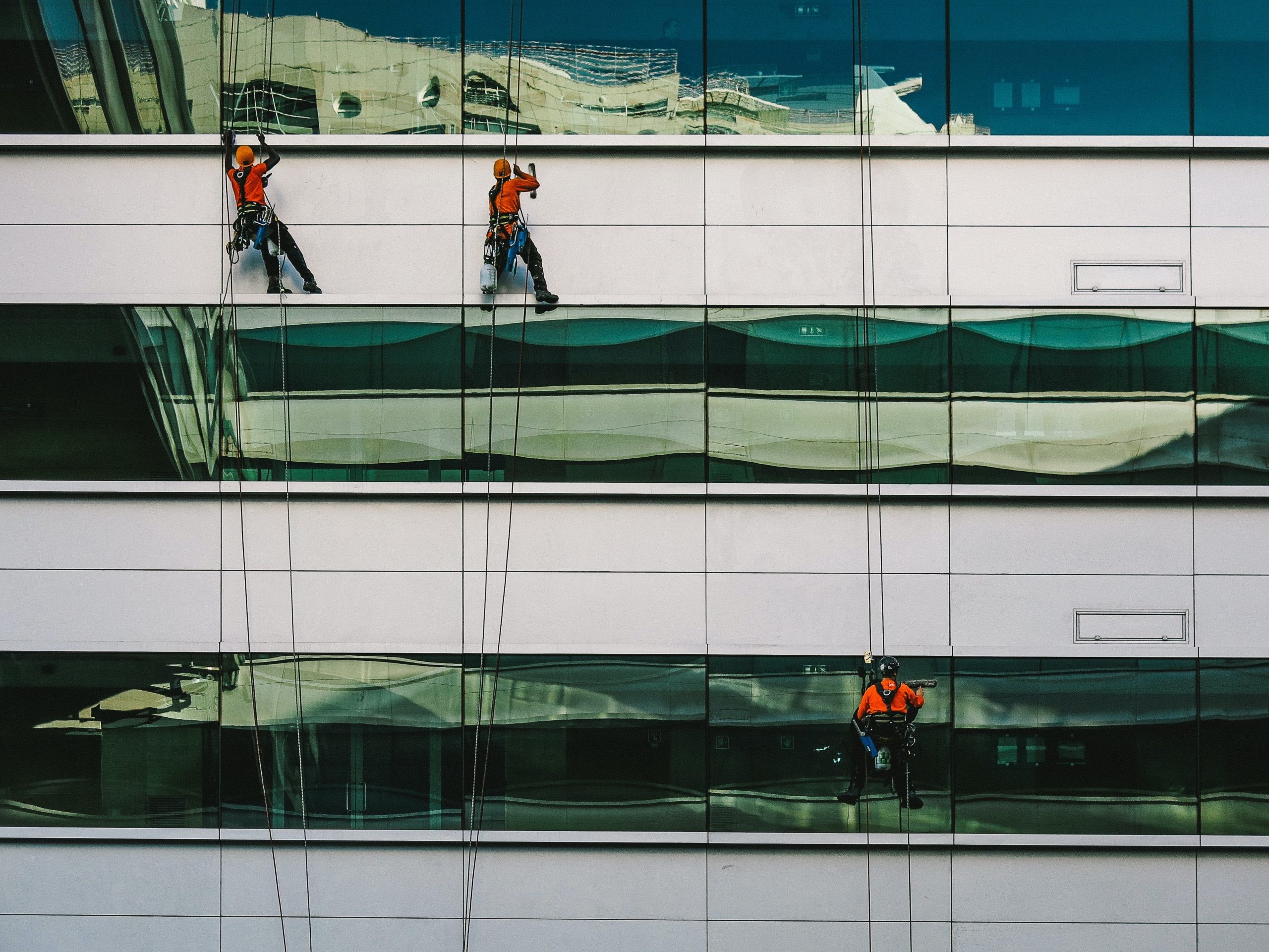 Window film installers installing window film on a building