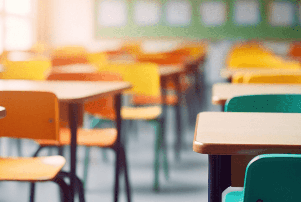 empty school classroom with colorful chairs and desks