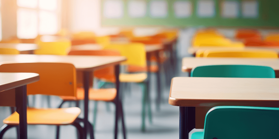 empty school classroom with colorful chairs and desks