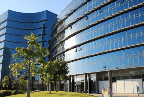 Exterior view of a modern office building with green space in front