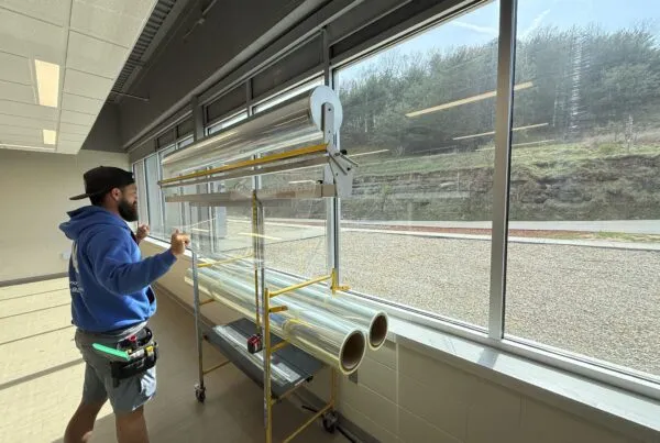 NGS window film installer installing security window film at Roane School District.
